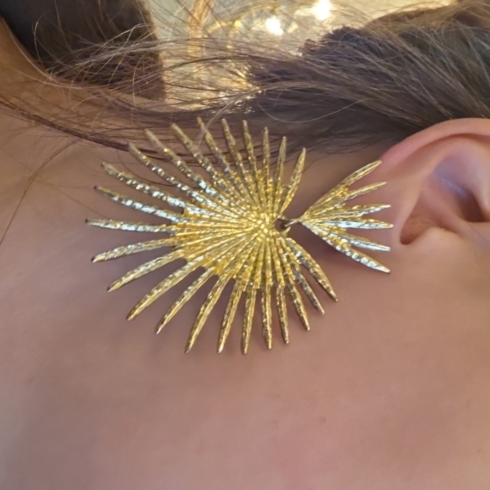 Gold-tone starburst heart-shaped statement earrings with a hammered finish. 